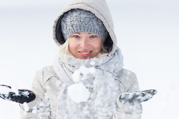 Image showing Girl  playing with snow in winter.