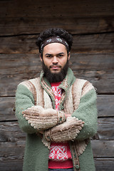 Image showing portrait of young hipster in front of wooden house