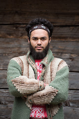 Image showing portrait of young hipster in front of wooden house