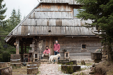 Image showing frineds together in front of old wooden house