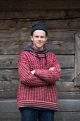 Image showing young hipster in front of wooden house