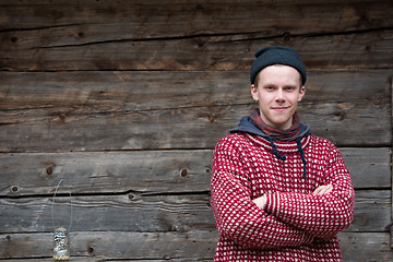 Image showing young hipster in front of wooden house