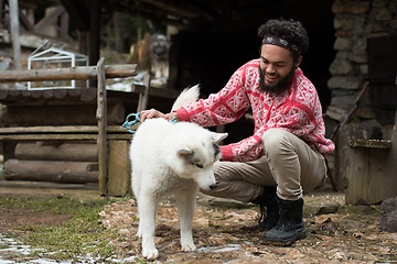 Image showing hipster with dog in front of wooden house