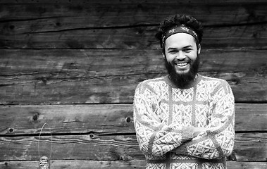 Image showing portrait of young hipster in front of wooden house