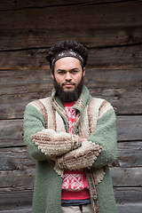 Image showing portrait of young hipster in front of wooden house