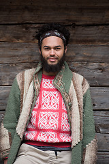 Image showing portrait of young hipster in front of wooden house