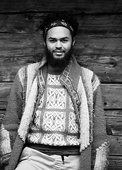 Image showing portrait of young hipster in front of wooden house