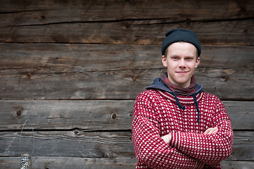 Image showing young hipster in front of wooden house