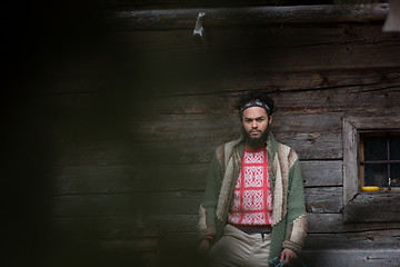 Image showing portrait of young hipster in front of wooden house