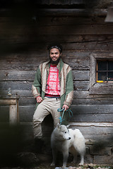 Image showing hipster with dog in front of wooden house