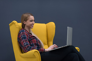 Image showing startup business, woman  working on laptop and sitting on yellow