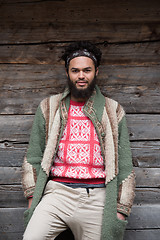 Image showing portrait of young hipster in front of wooden house