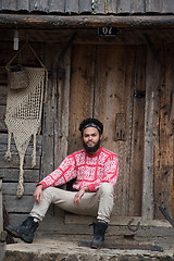 Image showing portrait of young hipster in front of wooden house