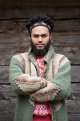 Image showing portrait of young hipster in front of wooden house