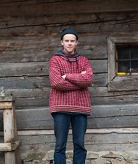 Image showing young hipster in front of wooden house