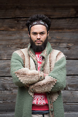 Image showing portrait of young hipster in front of wooden house