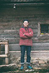 Image showing young hipster in front of wooden house