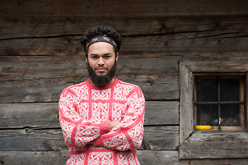 Image showing portrait of young hipster in front of wooden house