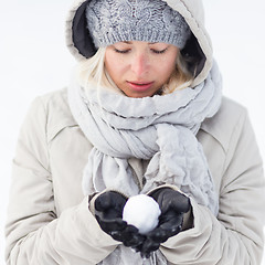 Image showing Girl  holding snowball in cold winter time.