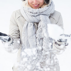 Image showing Girl  playing with snow in winter.
