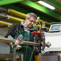 Image showing Industrial worker setting orbital welding machine.