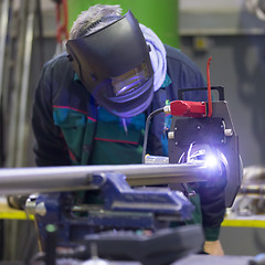 Image showing Industrial worker setting orbital welding machine.