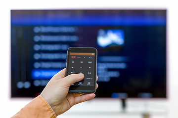 Image showing Closeup on woman hand holding smartphone and use a app with remo