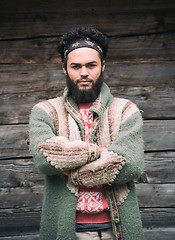 Image showing portrait of young hipster in front of wooden house