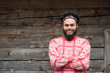 Image showing portrait of young hipster in front of wooden house