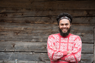 Image showing portrait of young hipster in front of wooden house