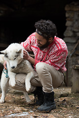 Image showing hipster with dog in front of wooden house