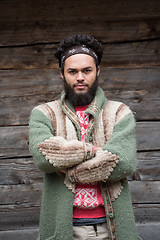 Image showing portrait of young hipster in front of wooden house