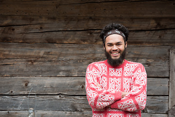 Image showing portrait of young hipster in front of wooden house