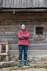 Image showing young hipster in front of wooden house