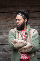 Image showing portrait of young hipster in front of wooden house