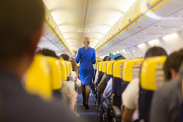 Image showing Stewardess and passengers on commercial airplane.