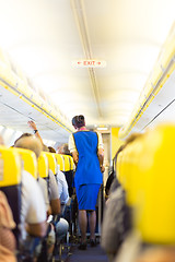 Image showing Stewardess and passengers on commercial airplane.