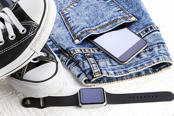 Image showing jeans and fashion accessories on white wooden