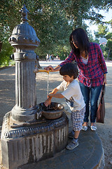 Image showing boy with his mother washing his hands under water stream from hy