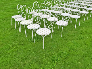 Image showing White chairs in the green field