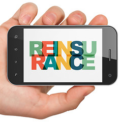 Image showing Insurance concept: Hand Holding Smartphone with Reinsurance on  display