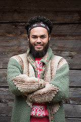 Image showing portrait of young hipster in front of wooden house