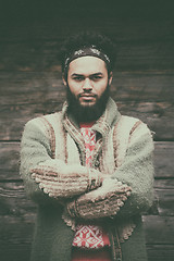 Image showing portrait of young hipster in front of wooden house