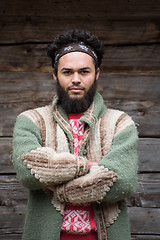 Image showing portrait of young hipster in front of wooden house