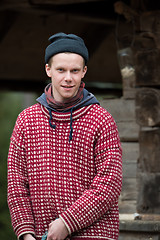 Image showing young hipster in front of wooden house