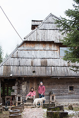 Image showing frineds together in front of old wooden house