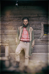 Image showing portrait of young hipster in front of wooden house