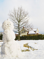 Image showing Snowman in garden half done, without scarf, hat and carrot in fr