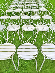 Image showing White chairs on green grass