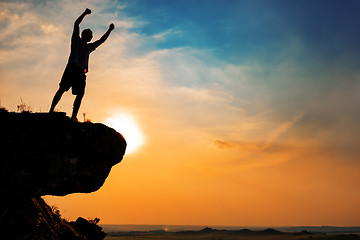 Image showing Man stands near the cross on top of mountain